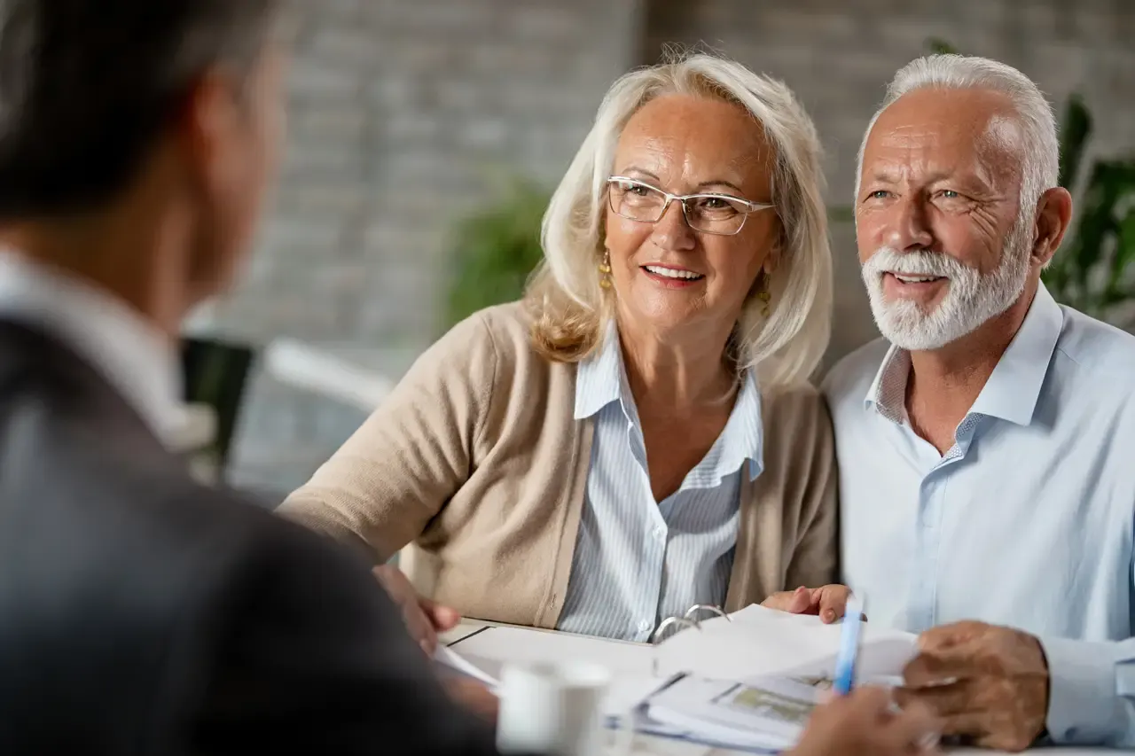 Couple de retraités souriants lors d'un rendez-vous de conseil